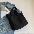 Minimalistische schwarze Segeltuchtasche mit Freizeit-Accessoires in der Draufsicht - Schwarz