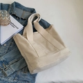 Minimalist cream canvas tote bag with outer pocket on denim jacket backdrop - Off White