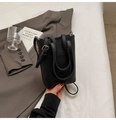 Détail du sac seau noir grainé avec poche frontale, poignées doubles et bandoulière fine - Noir