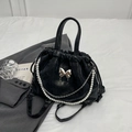 Bolso saco negro con mariposa, cadena de perlas y textura de cuero brillante - Negro