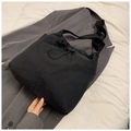 Dettaglio borsa tote in nylon nero impermeabile con coulisse su giacca grigia elegante - Senza Ciondolo / Nero