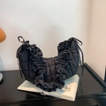 Chic black quilted dumpling bag with ruffle edges and soft fabric in a stylish setup - Black