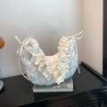 White ruffled dumpling bag with quilted texture and drawstring accents in a stylish design - White