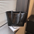 Grand sac cabas en cuir noir plissé avec breloque cœur et bandoulières sur un rebord - Noir