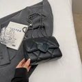 Schicke schwarze Stepptasche mit Herzschließe und silberner Kette auf einem Blazer - Schwarz Groß