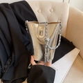 Chic silver metallic bucket bag with twist lock closure and chain strap in a lifestyle setting - Silver