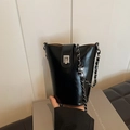 Minimalist black glossy bucket bag with silver chain strap and metal lock closure - Black