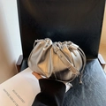 Metallisch silberne Cloud-Bag mit Raffung, Kettenriemen und Logo auf schwarzem Stuhl - Silber