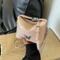 Pink pearlescent bucket bag featuring a silver butterfly buckle and adjustable strap - Pink