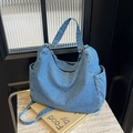 Sac bandoulière rétro en denim bleu délavé grande capacité sur du marbre - Bleu