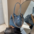 Blue denim tote bag with brown leather handles and brand woven label on side - Light Blue