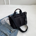 Bolso tote de lona negra con asas de cuero marrón y correa ajustable al hombro - Negro