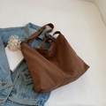Bolso tote de lona marrón oscuro con correa ajustable sobre una chaqueta vaquera - Marrón
