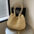 Sac fourre-tout minimaliste en paille tissée beige avec poignées sur une table en métal - Blanc Cassé