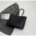 Flat lay of black embossed tote bag with cartoon patterns on white fabric background - Black without Pendant