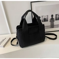 Detail view of the black canvas tote bag showing the adjustable shoulder strap and metal buckle - Black