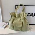 Bolso tote de pana verde claro con cierre de cordón y detalle de bolsillo frontal. - Verde