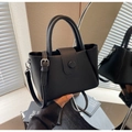 Detail of black lychee grain leather tote bag with round handle and adjustable strap - Black