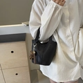 Schwarze Beuteltasche aus Leder mit Narbenstruktur, Gold-Beschlägen und Bären-Anhänger - Mit Strick Bärenanhänger / Schwarz