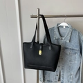 Bolso tote negro de cuero granulado con cierre dorado junto a chaqueta vaquera - Negro