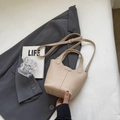 Beige lychee leather bucket bag with adjustable strap on a grey blazer backdrop - Without Pendant / Apricot