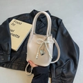 Cream bucket bag featuring pearl bow and silver heart pendant with shoulder strap - Off-white