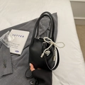 Chic black litchi leather bucket bag with pearl bow and silver heart pendant detail - Black