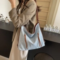 Sac fourre-tout en denim bleu clair avec lanières marron dans un café chaleureux - Marron