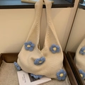 Beige crochet flower tote bag with blue and yellow floral accents in a cozy setting - Blue