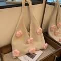 Beige knit tote bag with 3D crochet flowers on a wooden stand in a mirrorscene - Pink
