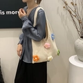 Beige crochet floral tote bag with colorful 3D flowers shown on shoulder by model - Colorful
