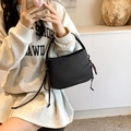 Minimalistische schwarze matte Ledertasche mit seitlichen Knoten und Bogengriff - Schwarz