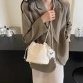 Beige Eimer-Tasche mit Lychee-Muster, goldener Kette und Plüsch-Anhänger - Cremeweiß