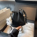Elegant black bucket bag with lychee texture, golden chain strap, and plush bear charm - Black