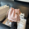 Pink drawstring bucket bag in pebble leather with gold chain strap and fur charm accessory - Pink