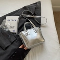 Silver metallic bucket bag with rivet accents and adjustable strap on white bedding - Silver (Without Pendant)