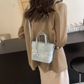 Borsa in tweed celeste con ciondolo a anello argento e tracolla sottile indossata dal modello - Blu