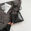 Chic black glossy faux leather shoulder bag with sleek curved design and knot detail - Without Ornament / Black