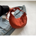 Detail view of a burnt orange nylon crescent bag with adjustable strap and zipper - No Pendant / Orange