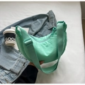 Detail of mint green nylon crescent bag on denim jacket with lifestyle accessories - No Pendant / Green