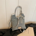 Light blue denim shoulder bag with silver studs, faux pearl bow, and leather tag - Blue
