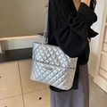 Bolso tote acolchado plateado metalizado llevado por modelo en un entorno interior - Plateado