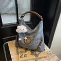 Dettaglio borsa tote in denim blu con manici in pelle marrone e logo M in argento - Blu Denim Con Ciondolo