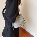 Gray drawstring bucket bag with textured fabric and metallic chain strap shown on model - Blue