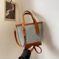 Bolso cubo retro de mezclilla con ribete de cuero marrón y correa sobre fondo blanco - Marrón
