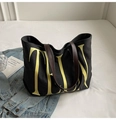 Close-up of black canvas tote bag showing durable leather handles and yellow typography - Black