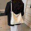 Beigefarbene Hobo-Tasche mit geometrischer Textur und silberner Kette am Modell - Cremeweiß