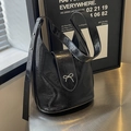 Glossy black pleated bucket bag with silver bow accent and versatile shoulder straps - Black