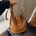 Caramel brown bucket bag in glossy faux leather with a metal bow accent for women - Brown