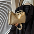 Luxe champagnegouden kussentas met metallic afwerking en een brede schouderriem - Goud